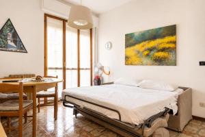 a bedroom with a bed and a table and a painting at oasi corallo in Diano Marina