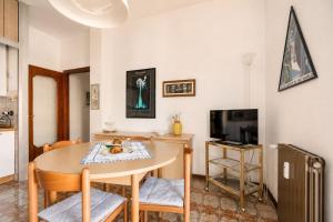 a dining room with a table and a television at oasi corallo in Diano Marina