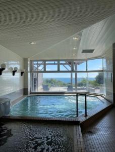 a large swimming pool in a building with a large window at 鉾田の家 in Hokota
