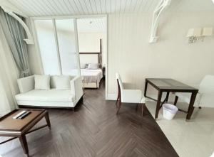a living room with a couch and a table and a bed at Pattaya Private Beach - Grand Florida Beachfront Condo Resort in Na Jomtien +76 photos