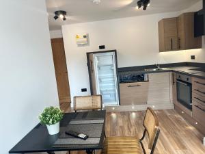a kitchen with a table and chairs and a refrigerator at Roundhay Residences in Moortown