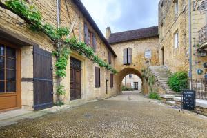 an alley in an old building with an archway at Gite de l'Egal in Le Buisson de Cadouin