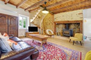 a living room with a couch and a fireplace at Gite de l'Egal in Le Buisson de Cadouin