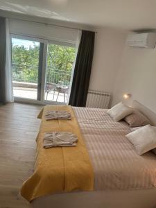 a bedroom with a large bed with towels on it at Apartmani ViVa in Lovran