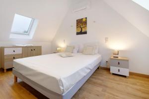 a bedroom with a large white bed and a window at Gite de l'Egal in Le Buisson de Cadouin +30 photos