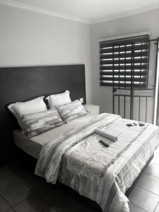 a bedroom with a large bed with a laptop on it at Fullmoon Homes 9A in Edenvale