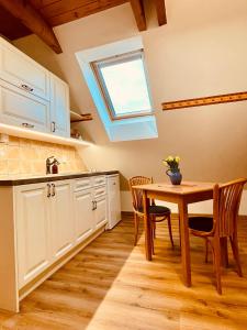 a kitchen with a table and a skylight at Ubytování u Chladů in Horská Kvilda