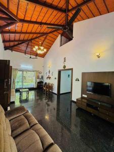 a living room with a couch and a flat screen tv at Rego Farms in Mangalore