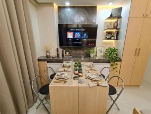 a long table with chairs and a television in a room at Midtown Cebu City Condo in Cebu City