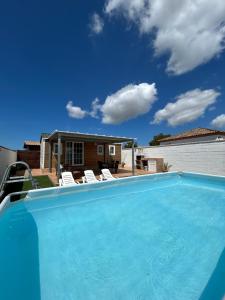 a swimming pool with chairs and a house at Casita la Loma in Cádiz