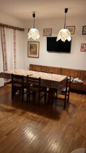 a dining room table with chairs and a television at Appartamento Tulipano in Nevegal