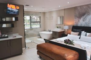 a bathroom with a large bed and a tub and a sink at Palmera Guest House in Krugersdorp +40 photos