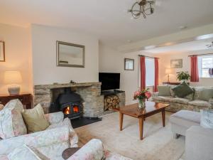 a living room with a couch and a fireplace at Harbins Farm in Sherborne