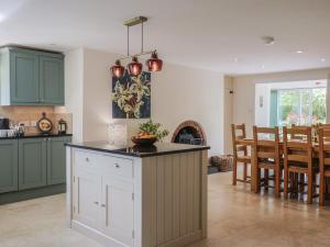 a kitchen with green cabinets and a dining room at Harbins Farm in Sherborne