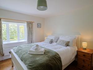 a bedroom with a bed with a towel on it at Harbins Farm in Sherborne