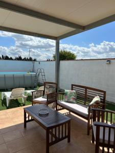 a patio with chairs and a table and a pool at Casita la Loma in Cádiz