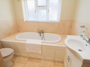 a bathroom with a tub and a sink at The Stables at Hall Barn in Diss +24 photos