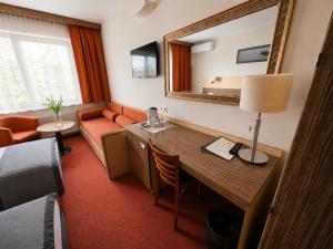 a hotel room with a desk and a couch at Info Hotel in Palanga
