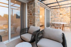 a patio with two chairs and a table on a balcony at Gialova Hills 8 in Gialova