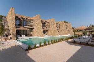 a large brick building with a swimming pool and umbrellas at Gialova Hills 8 in Gialova