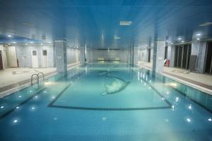 a large swimming pool with blue water in a building at Grand Ali'n Tokat in Tokat