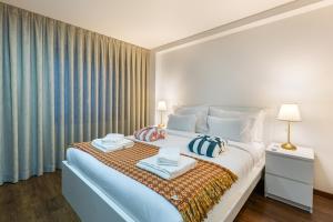 a bedroom with a large bed with two towels on it at Luxury by ON Apartments in Porto +101 photos