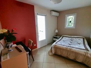 a bedroom with a bed and a table and a window at Gîte Bouconne Pibrac in Pibrac