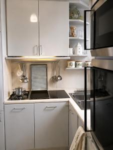 eine Küche mit weißen Schränken und einem Herd mit Backofen in der Unterkunft White Suite Capri in Capri + 17 Fotos
