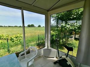 a screened porch with a table and chairs and a view of a field at Gîte Bouconne Pibrac in Pibrac