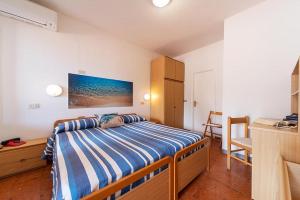 a bedroom with a bed with blue and white striped sheets at B&B Hotel Il Veliero - la vela del veliero in SantʼAndrea +36 photos