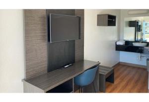 a room with a desk with a flat screen tv at Motel 6 Gulfport, MS Airport in Gulfport