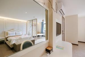 a bedroom with a bed and a large mirror at Tina 5 hotel cần thơ in Ấp Phú Thạnh (4)
