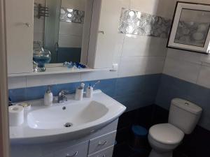 a bathroom with a white sink and a toilet at Terra Naxos in Galini +25 photos