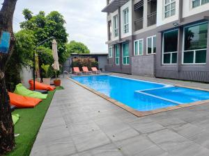 ein Swimmingpool in einem Hof neben einem Gebäude in der Unterkunft Crystal Suites Suvarnbhumi Airport in Lat Krabang