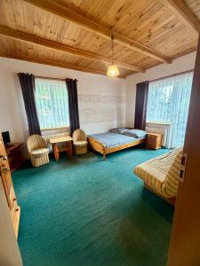 a bedroom with two beds and chairs in a room at Zimorodek smart tv NETFLIX pokoje SUPERIOR z balkonami Las Szlaki Aquapark in Karpacz