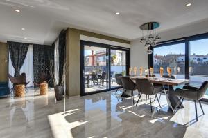 a dining room with a table and chairs and windows at Villa Orion - Private Heated Pool, Sauna & Jacuzzi in Rovinj