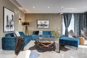 a living room with a blue couch and a table at Villa Orion - Private Heated Pool, Sauna & Jacuzzi in Rovinj
