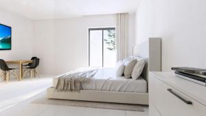 a white bedroom with a bed and a table at Ferienwohnung Apartment am Moosrain in Eitting