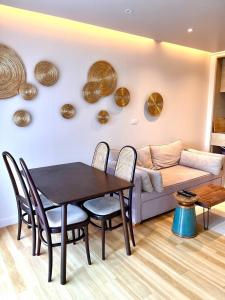 a dining room with a table and a couch at Coconut Suite Aonang in Ao Nang Beach