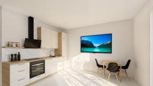 a kitchen with a table and a tv on the wall at Ferienwohnung Apartment am Moosrain in Eitting
