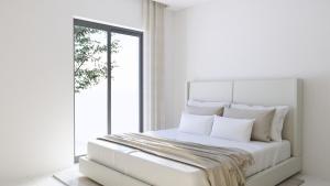 a white bedroom with a large bed with white pillows at Ferienwohnung Apartment am Moosrain in Eitting