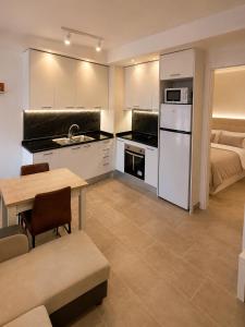 a kitchen with white cabinets and a table and a bed at Residencial Lleida in Lleida