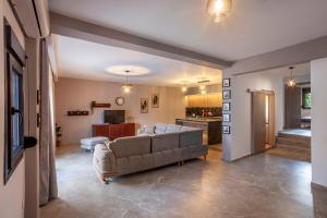 a living room with a couch and a kitchen at Old Square House in Pefkochori