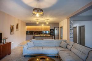a living room with a blue couch and a kitchen at Old Square House in Pefkochori