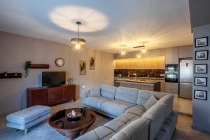 a living room with a blue couch and a kitchen at Old Square House in Pefkochori +37 photos
