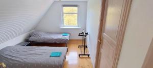 a attic room with two beds and a window at M1 Stay in Bevtoft