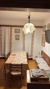 a dining room with a table and a chandelier at Appartamento Tulipano in Nevegal