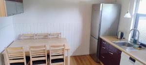 a kitchen with a table and chairs and a refrigerator at M1 Stay in Bevtoft +3 photos