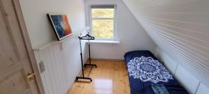 a small attic room with a bed and a window at M1 Stay in Bevtoft