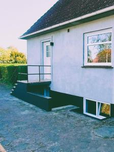 a house with a porch and stairs on it at M1 Stay in Bevtoft